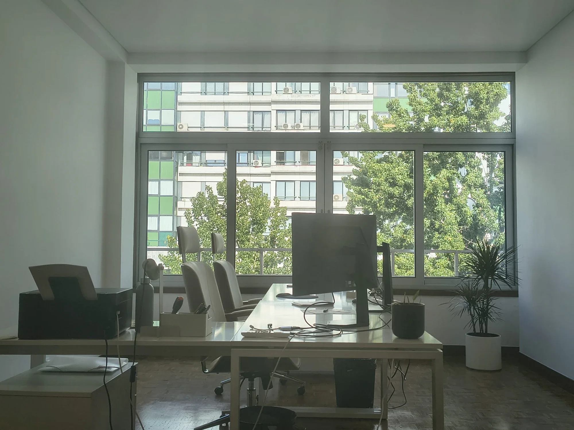 Sala de trabalho do atelier VALRIO em Coimbra — luz natural sobre a zona de desenho